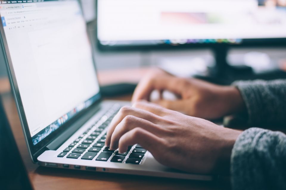 Hände tippen auf einer Notebook-Tastatur