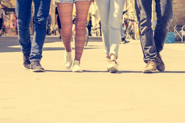 Vier Menschen gehen nebeneinander auf einer Straße